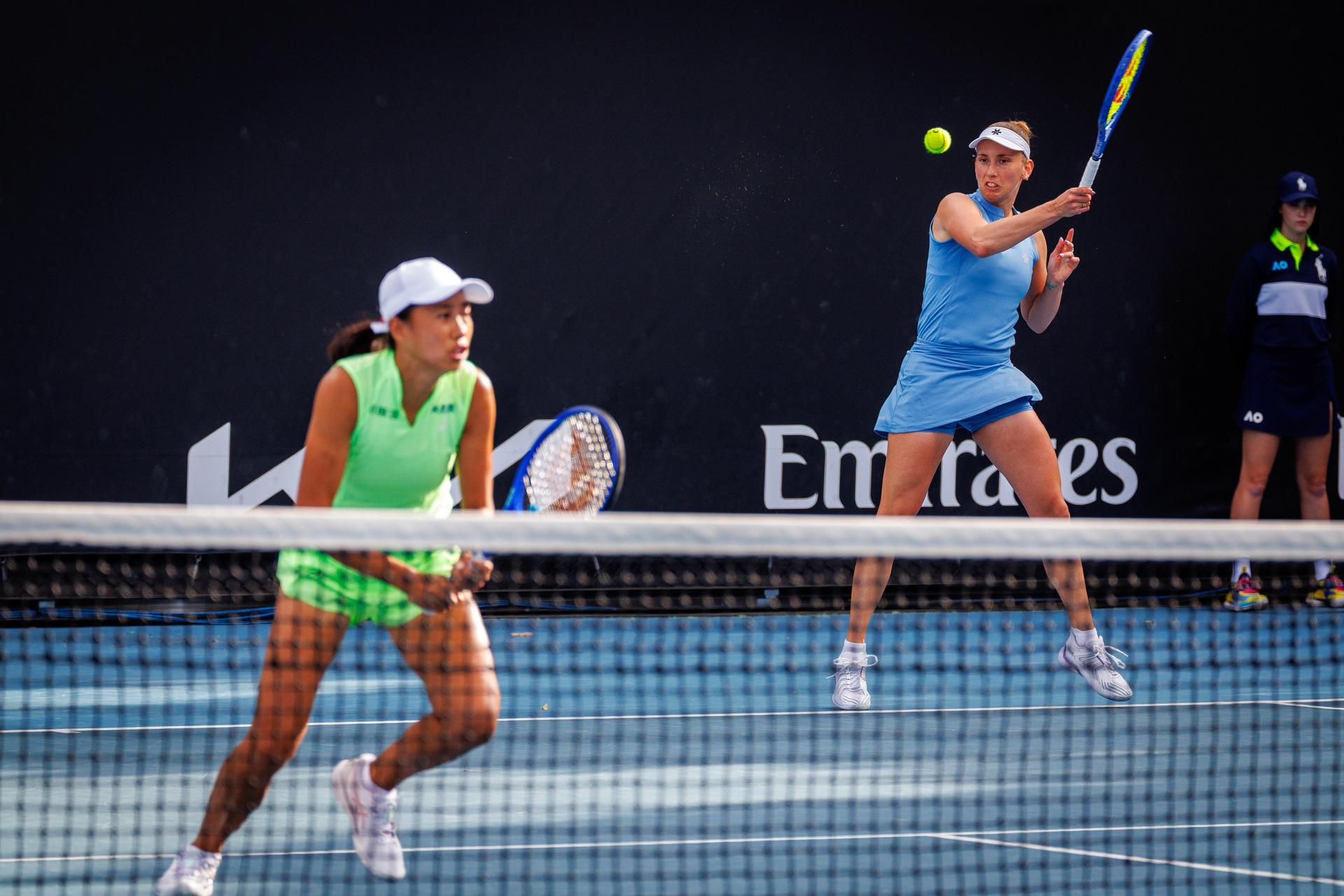 Belgian Elise Mertens (blue, R) and Chinese Zhang Shuai (green) pictured during a first round match of Belgium-China's Mertens-Shuai pair against Romania-Russia's pair Cirstea-Kalinskya in the women doubles at the Australian Open, Melbourne Park, Melbourne on Wednesday 21 January 2026. Mertens - Shuai won the game. BELGA PHOTO PATRICK HAMILTON  --- BENELUX ONLY   ---