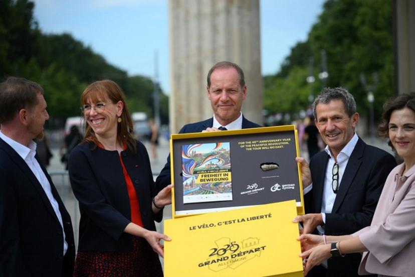 Tour de France director Christian Prudhomme (C) poses for a group photo with the bid for the 2029 Tour de France (TDF) departure in Berlin, in front of landmark Brandenburg Gate with (L-R) Saxony's State Premier Michael Kretschmer, Member of the Saxon State Parliament Katja Meier, ASO (Amaury Sport Organisation)'s CEO Yann Le Moenner and government's commissionner for Eastern Germany Elibeth Kaiser (R) in Berlin, Germany, on July 29, 2026.   RALF HIRSCHBERGER / AFP