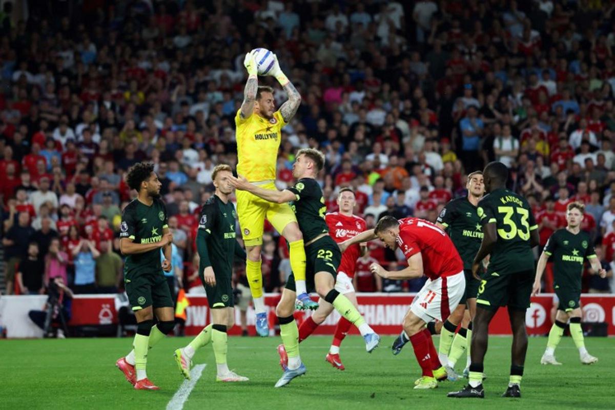 Brentford's Dutch goalkeeper #01 Mark Flekken (C) jumps to catch the ball during the English Premier League football match between Nottingham Forest and Brentford at The City Ground in Nottingham, central England, on May 1, 2025.  Darren Staples / AFP