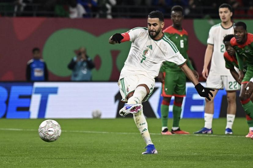 Algeria's forward #7 Riyad Mahrez (L) shoots and scores his team's first goal from the penalty spot during the Africa Cup of Nations (CAN) Group E football match between Algeria and Burkino Faso at Moulay Hassan Stadium in Rabat on December 28, 2025.   Paul ELLIS / AFP