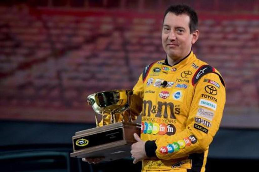 2015 NASCAR Sprint Cup Series Champion Kyle Busch carries the 2016 NASCAR Manufacturers Trophy at the Toyota press conference during the 2017 North American International Auto Show in Detroit, Michigan, January 9, 2017. 
JIM WATSON / AFP