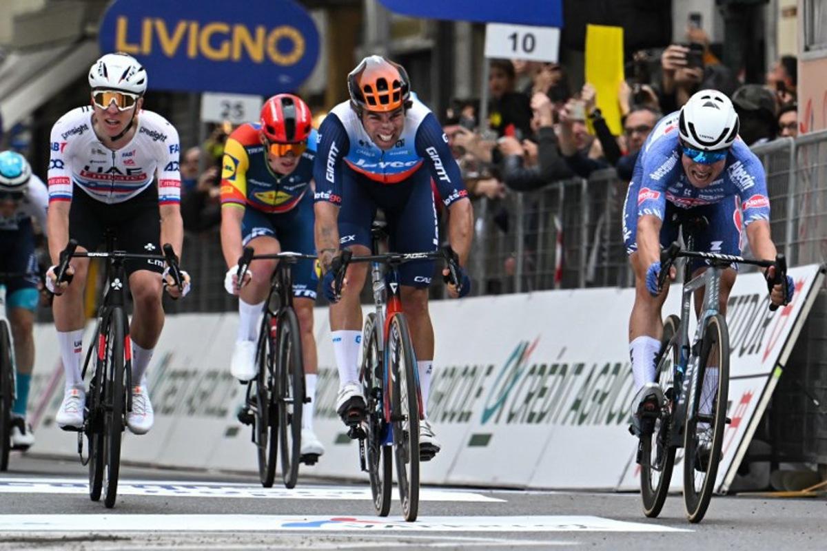 Alpecin-Deceuninck's Belgian rider Jasper Philipsen (R) cycles to cross the finish line ahead of Team Jayco Alula's Australian rider Michael Matthews (C)  and UAE Team Emirates' Slovenian rider Tadej Pogacar (L) during the 115th Milan-SanRemo one-day classic cycling race, between Pavia and SanRemo, on March 16, 2024.  Marco BERTORELLO / AFP