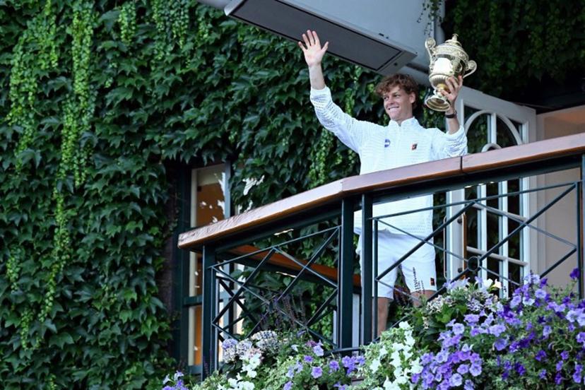 Italy's Jannik Sinner waves from the balcony after winning the men's singles final tennis match against Germany's Alexander Zverev on the last day of the 2026 Wimbledon Championships at The All England Lawn Tennis and Croquet Club in Wimbledon, southwest London, on July 12, 2026.  Kirill KUDRYAVTSEV / AFP