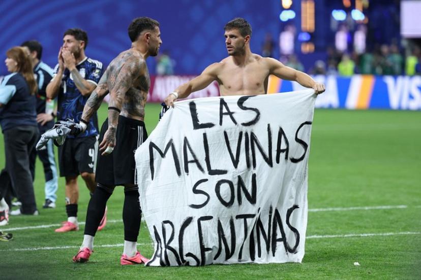 Argentina's defender #19 Nicolas Otamendi (L) and midfielder #11 Giovani Lo Celso show a banner that reads in Spanish, "The Malvinas (Falkland Islands) belong to Argentina," after winning the 2026 World Cup football tournament semi-final match between England and Argentina at the Atlanta Stadium in Atlanta on July 15, 2026.   Thomas COEX / AFP