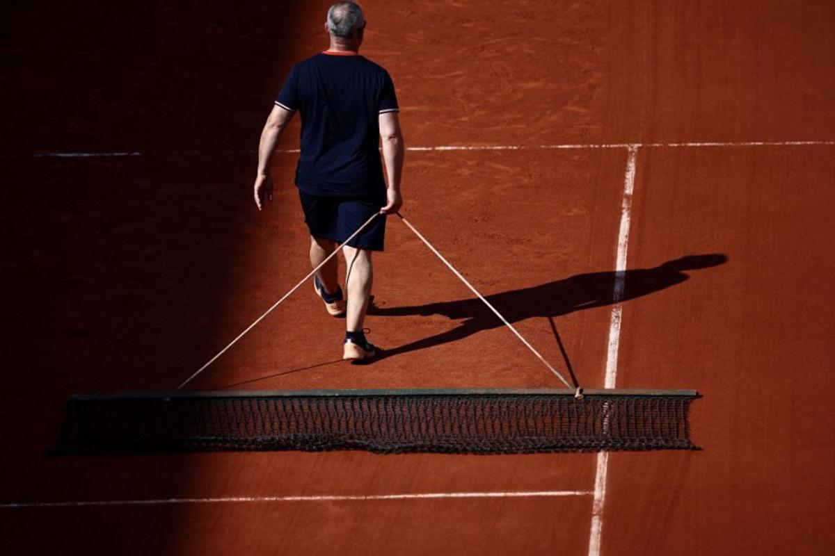 A worker flatens the clay of the Court Suzanne-Lenglen on day two of the Roland-Garros Open tennis tournament in Paris on May 29, 2023.  Anne-Christine POUJOULAT / AFP