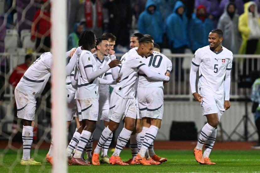 Switzerland's midfielder #17 Ruben Vargas (C) celebrates with teammates after scoring the opening goal during the FIFA World Cup 2026 European qualification Group B football between Kosovo and Switzerland at the Fadil Vokrri Stadium in Pristina, on November 18, 2025.  Armend NIMANI / AFP