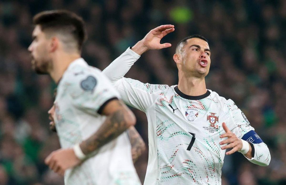 Portugal's forward Cristiano Ronaldo (R) reacts after missing a free kick during the men's football 2026 World Cup Group F qualifier between Ireland and Portugal at Aviva Stadium in Dublin on November 13, 2025.  Paul Faith / AFP