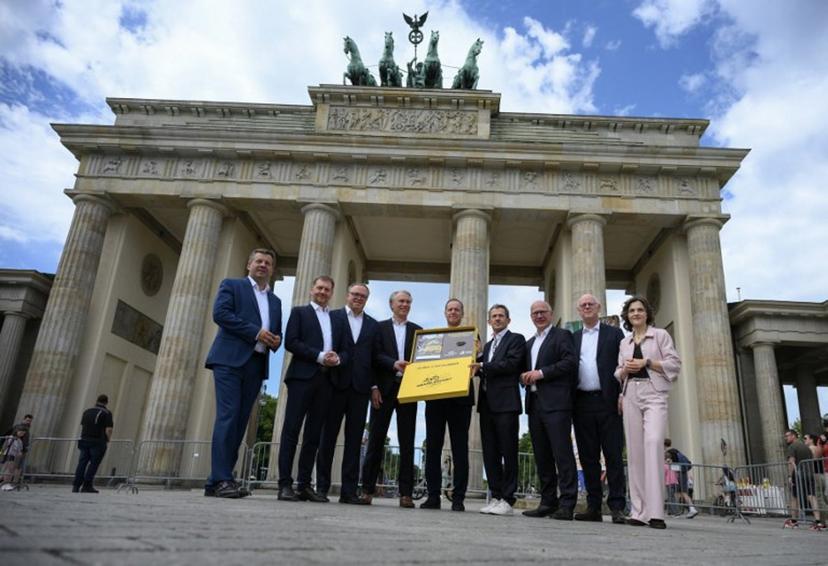 Tour de France director Christian Prudhomme (C) poses for a group photo with the bid for the 2029 Tour de France (TDF) departure in Berlin, in front of landmark Brandenburg Gate with German Cycling Association Bernd Dankowski (4thL) and ASO (Amaury Sport Organisation)'s CEO Yann Le Moenner (4theR), and (L-R) Saxony-Anhalt's State Premier Sven Schulze, Saxony's State Premier Michael Kretschmer, Thuringia's State Premier Mario Voigt, Berlin's mayor Kai Wegner, former President of the German Cycling Federation Rudolf Scharping and the government's commissionner for Eastern Germany Elisabeth Kaiser, in Berlin, on July 29, 2026.  RALF HIRSCHBERGER / AFP