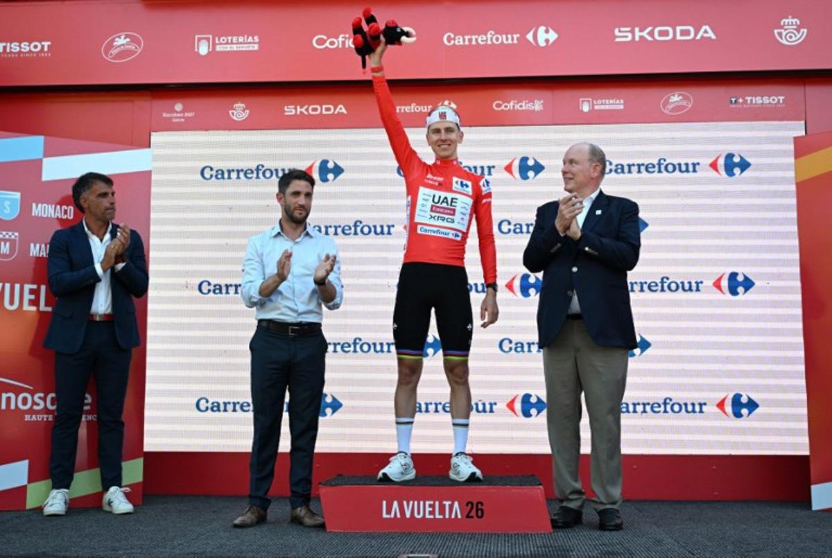 UAE Team Emirates - XRG team's Slovenian rider Tadej Pogacar celebrates on the podium wearing the overall leader's red jersey flanked by (from R) Prince's Albert II of Monaco, Manosque's mayor Camille Galtier and Spanish former Tour de France winner Oscar Pereiro after the second stage of the Vuelta a Espana 2026, a 214,3 km race between Monaco and Manosque on August 23, 2026.  Miguel MEDINA / AFP