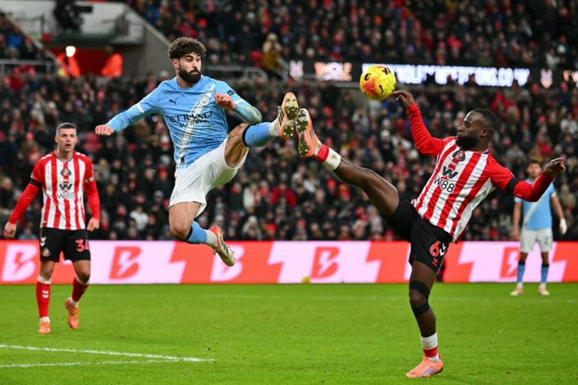 Manchester City's Croatian defender #24 Josko Gvardiol (C) leaps for a ball against Sunderland's Dutch defender #06 Lutsharel Geertruida (R) during the English Premier League football match between Sunderland and Manchester City at The Stadium of Light in Sunderland in north east England on January 1, 2026.  ANDY BUCHANAN / AFP