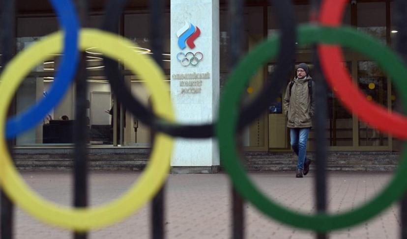 A man walks past the logo of the Russian Olympic Committee (ROC) as he leaves the office in Moscow on October 15, 2024. The head of Russia's Olympic Committee announced his resignation on October 15, 2024, a surprise move that comes as Moscow faces isolation from international sport over its Ukraine offensive. Former fencer, Stanislav Pozdnyakov, a five-time Olympic medallist, said in his resignation letter there were "timely" reasons why Russian sport needed a new leader, without going into detail. Natalia KOLESNIKOVA / AFP