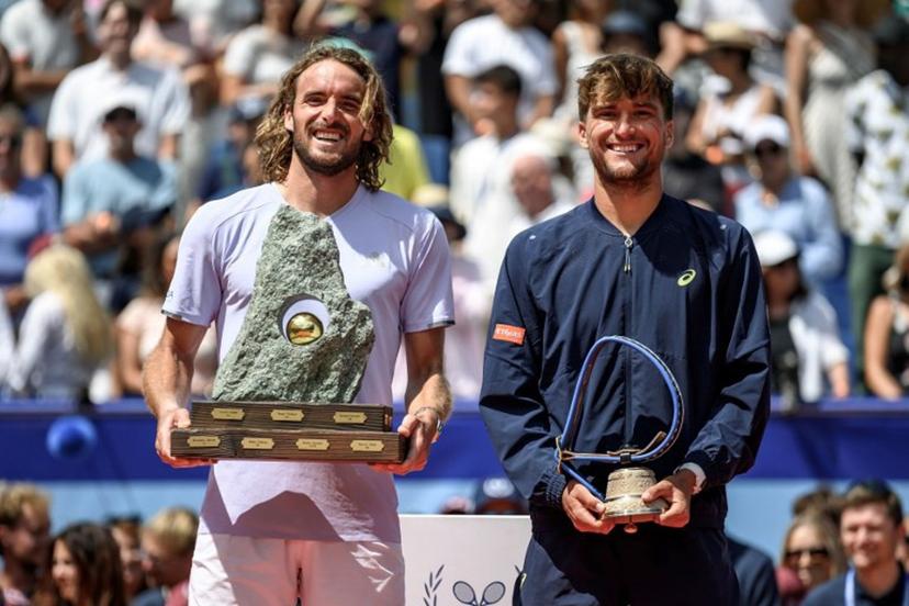 Greece's Stefanos Tsitsipas (L) poses with the trophy following his victory against Belgium's Raphael Collignon (R) during their men's singles final match at the Swiss Open tennis tournament in Gstaad, on July 19, 2026.  Fabrice COFFRINI / AFP