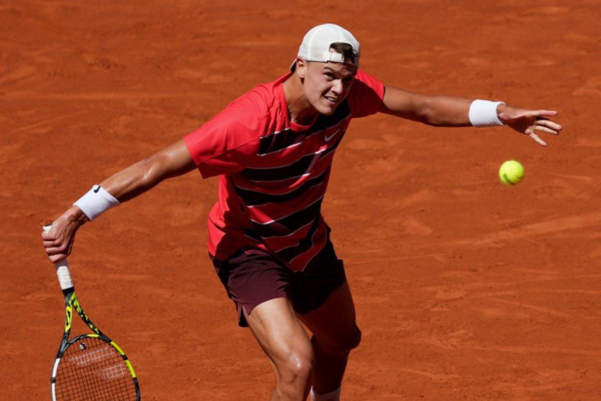 Denmark's Holger Rune plays a backhand return to France's Quentin Halys during their men's singles match on day 6 of the French Open tennis tournament on Court Philippe-Chatrier at the Roland-Garros Complex in Paris on May 30, 2025.  Dimitar DILKOFF / AFP