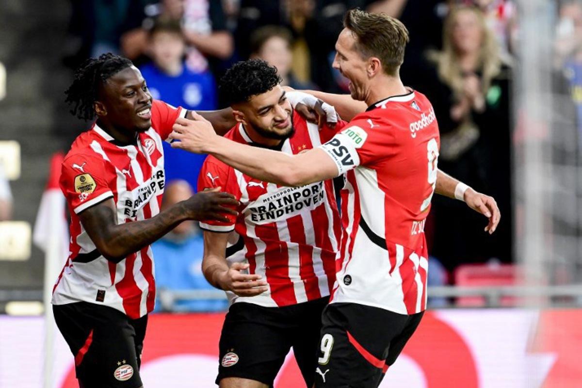 PSV's Moroccan midfielder #34 Ismael Saibari (C) celebrates with PSV's Dutch forward #09 Luuk de Jong (R) and PSV's Belgium forward #11 Johan Bakayoko (L) after scoring PSV's first goal during the Dutch Eredivisie fooball match between PSV Eindhoven and Almere City FC at the Phillips Stadium in Eindhoven on April 12, 2025.  Olaf Kraak / ANP / AFP