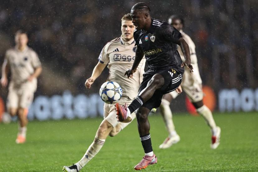 Ajax's Danish defender #03 Anton Gaaei and Qarabag's Ghanaian forward #11 Emmanuel Addai vie for the ball during the UEFA Champions League league phase football match between Qarabag and Ajax at the Tofiq Bahramov Republican Stadium in Baku on December 10, 2025.  Giorgi ARJEVANIDZE / AFP
