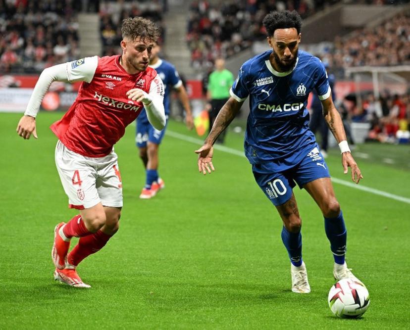 Reims' Belgian defender #04 Maxime Busi (L) fights for the ball with Marseille's French-Gabonese forward #10 Pierre-Emerick Aubameyang during the French L1 football match between Reims And Marseille on May 15, 2024 at Auguste-Delaune stadium in Reims.   FRANCOIS NASCIMBENI / AFP