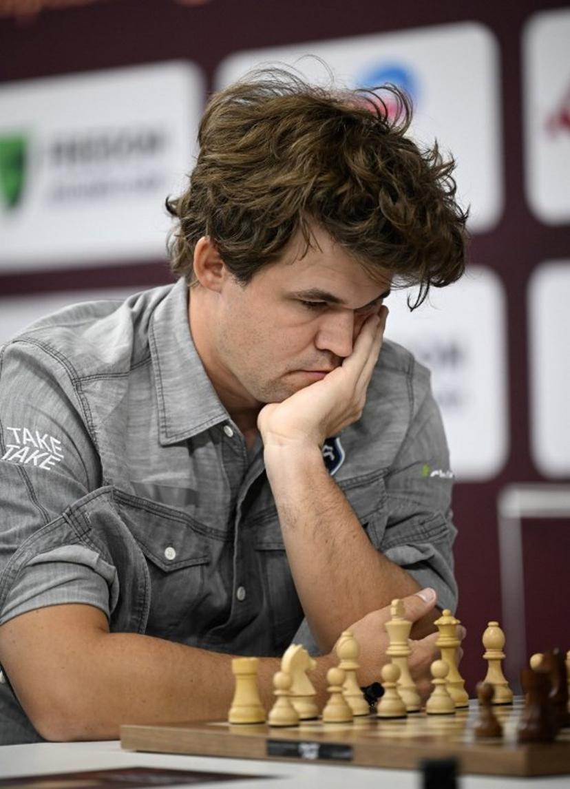 Magnus Carlsen of Norway plays against Rudik Makarian of Russia in the 15th round of the Blitz Open during the FIDE World Rapid and Blitz Championships 2025 at Qatar University's Sports and Events Complex in Doha on December 30, 2025.  Mahmud HAMS / AFP
