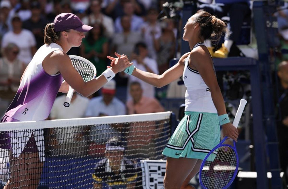China's Qinwen Zheng (R) shakes hands with Poland's Iga Swiatek after defeating her in their women's singles round of 16 tennis match on day nine of the US Open tennis tournament at the USTA Billie Jean King National Tennis Center in New York on September 7, 2026.  KENA BETANCUR / AFP