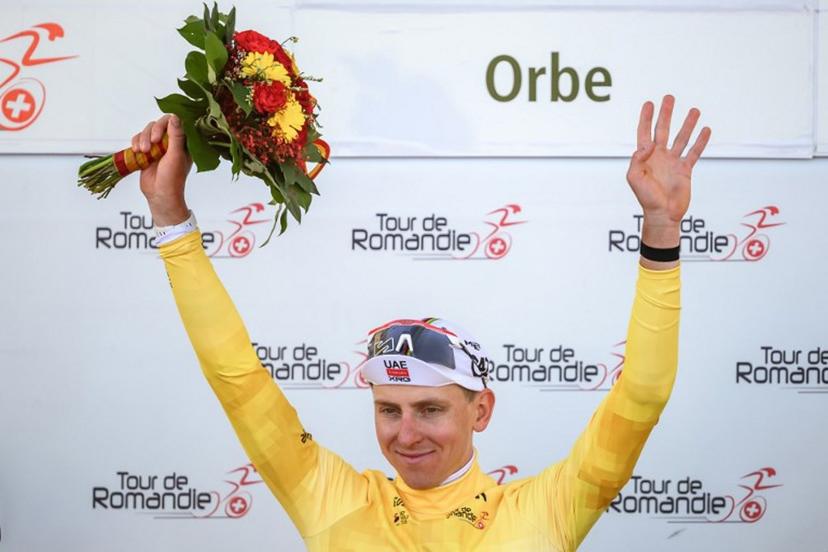 UAE Team Emirates-XRG's Slovenian rider Tadej Pogacar wearing the overall leader's yellow jersey raises his arms during the podium ceremony of the third stage of the Tour of Romandie UCI cycling World tour, a 176.6 km loop departing and arriving in Orbe, Switzerland, on May, 1, 2026.  Fabrice COFFRINI / AFP