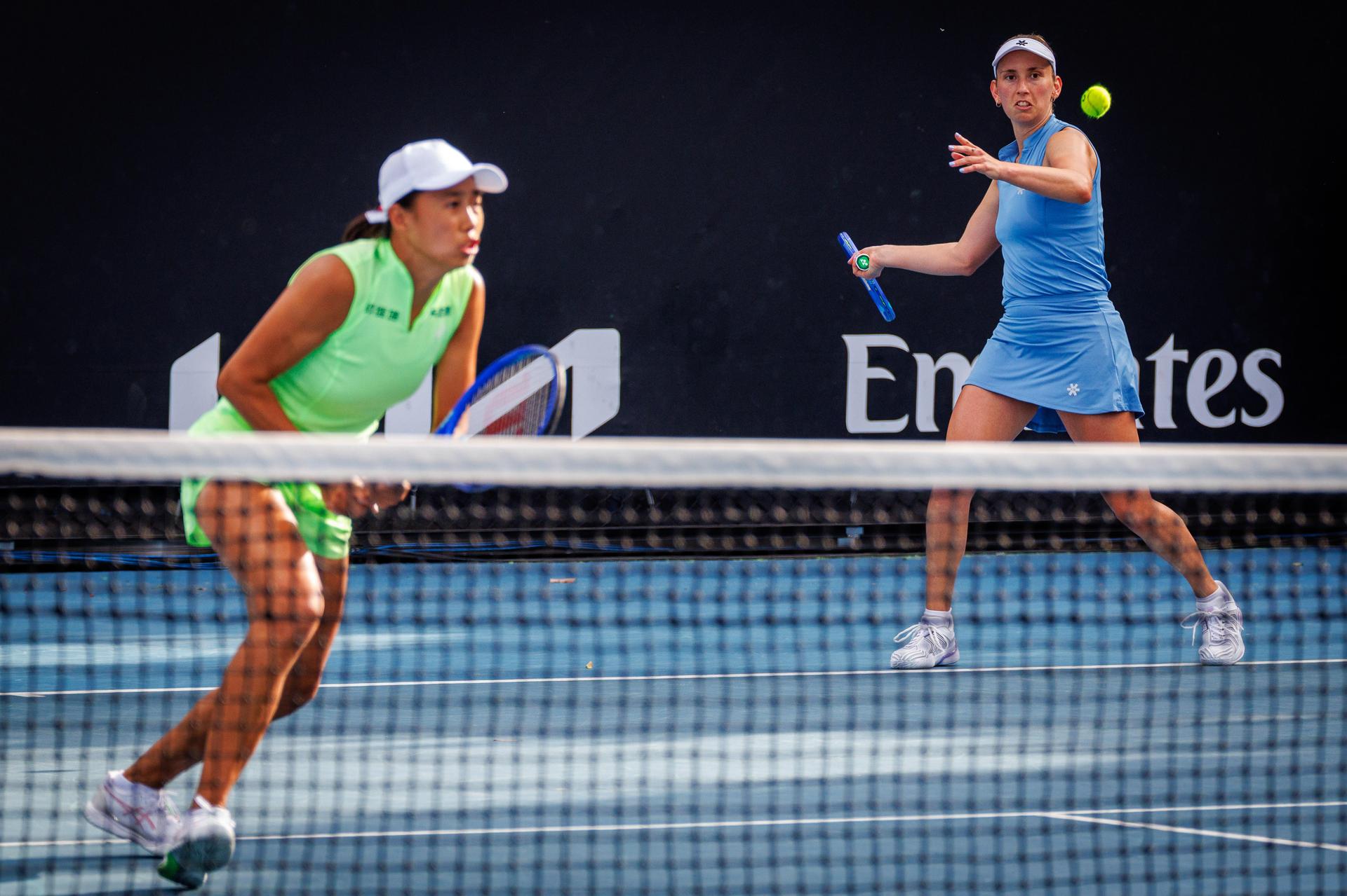 Belgian Elise Mertens (blue, R) and Chinese Zhang Shuai (green) pictured in action during a first round match of Belgium-China's Mertens-Shuai pair against Romania-Russia's pair Cirstea-Kalinskya in the women doubles at the Australian Open, Melbourne Park, Melbourne on Wednesday 21 January 2026. Mertens - Shuai won the game. BELGA PHOTO PATRICK HAMILTON  --- BENELUX ONLY   ---
