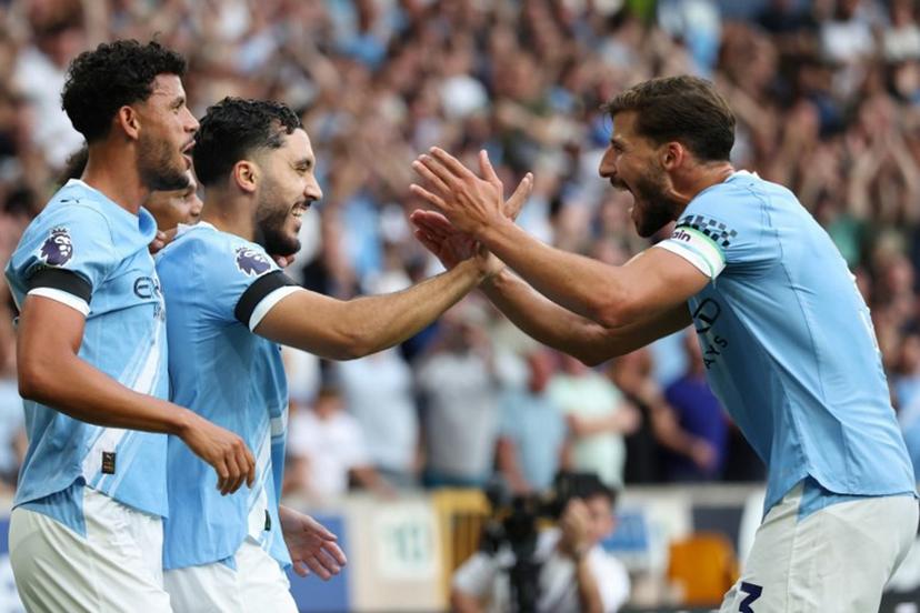 Manchester City's French midfielder #10 Rayan Cherki (2L) celeberates scoring their fourth goal with Manchester City's Portuguese defender #03 Ruben Dias (R) during the English Premier League football match between Wolverhampton Wanderers and Manchester City at the Molineux stadium in Wolverhampton, central England on August 16, 2025.  Darren Staples / AFP
