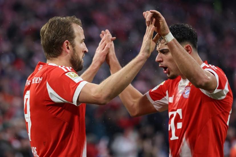Bayern Munich's English forward #09 Harry Kane celebrates scoring the 3-0 goal with his teammate Bayern Munich's German midfielder #45 Aleksandar Pavlovic during the German first division Bundesliga football match between FC Bayern Munich and Eintracht Frankfurt in Munich, southern Germany, on February 21, 2026.  Alexandra BEIER / AFP