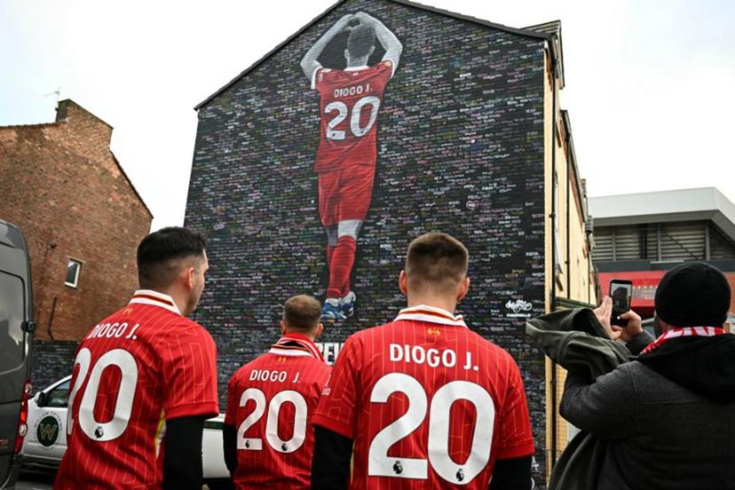 Fans visit a mural created by artist Murwalls, dedicated to Liverpool's late Portugese footballer Diogo Jota who died in a car crash in July, ahead of the English Premier League football match between Liverpool and Wolverhampton Wanderers at Anfield in Liverpool, north west England on December 27, 2025. Father of three Jota, who married his long-term partner Rute Cardoso 11 days before the accident, died alongside his brother after a Lamborghini they were travelling in came off the road and burst into flames in northern Spain in July. Oli SCARFF / AFP