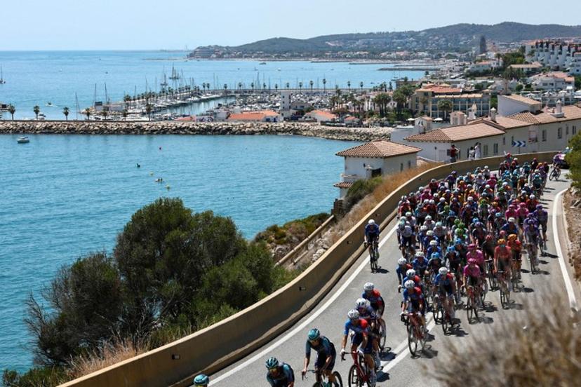 The pack of riders (peloton) cycles along the Mediterranean coastline near Sitges during the 2nd stage of the 113th edition of the Tour de France cycling race, 168,5 km between Tarragona and Barcelona in northeastern Spain, on July 5, 2026.  Anne-Christine POUJOULAT / AFP