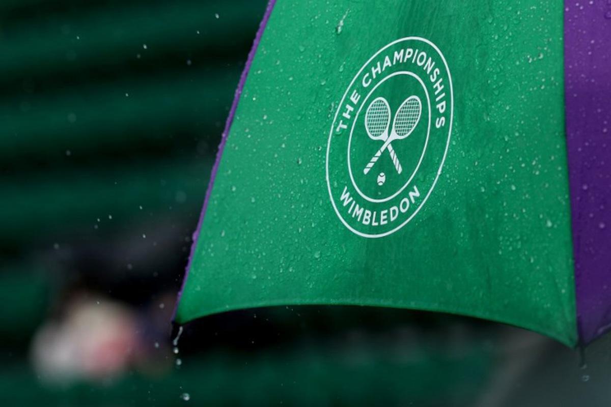 Rain falls from an umbrella on the seventh day of the 2025 Wimbledon Championships at The All England Lawn Tennis and Croquet Club in Wimbledon, southwest London, on July 6, 2025.  Adrian Dennis / AFP