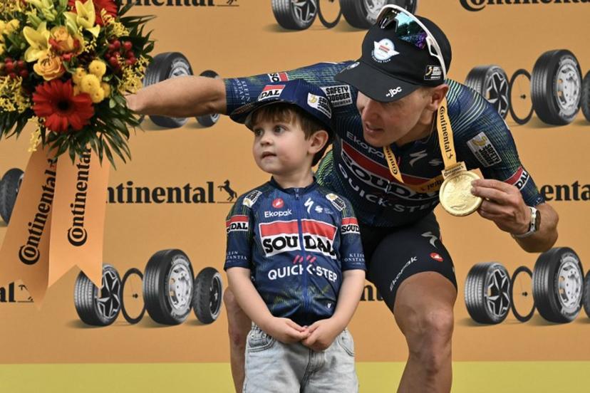 Soudal Quick-Step team's Belgian rider Tim Merlier celebrates on the podium with his son Jules after winning the 12th stage of the 113th edition of the Tour de France cycling race, 179,1 km between Circuit de Nevers Magny-Cours and Chalon-sur-Saône in central France, on July 16, 2026.  Jeff PACHOUD / AFP