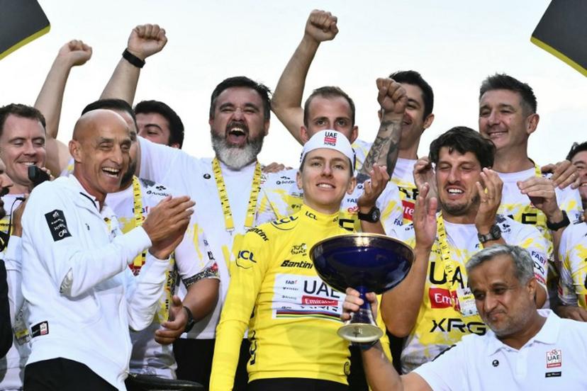 UAE Team Emirates - XRG team's Slovenian rider Tadej Pogacar wearing the overall leader's yellow jersey celebrates his overall victory with team staff after the 21st and final stage of the 112th edition of the Tour de France cycling race, 132.3 km between Mantes-la-Ville and Paris Champs-Élysees, on July 27, 2025.  Marco BERTORELLO / AFP