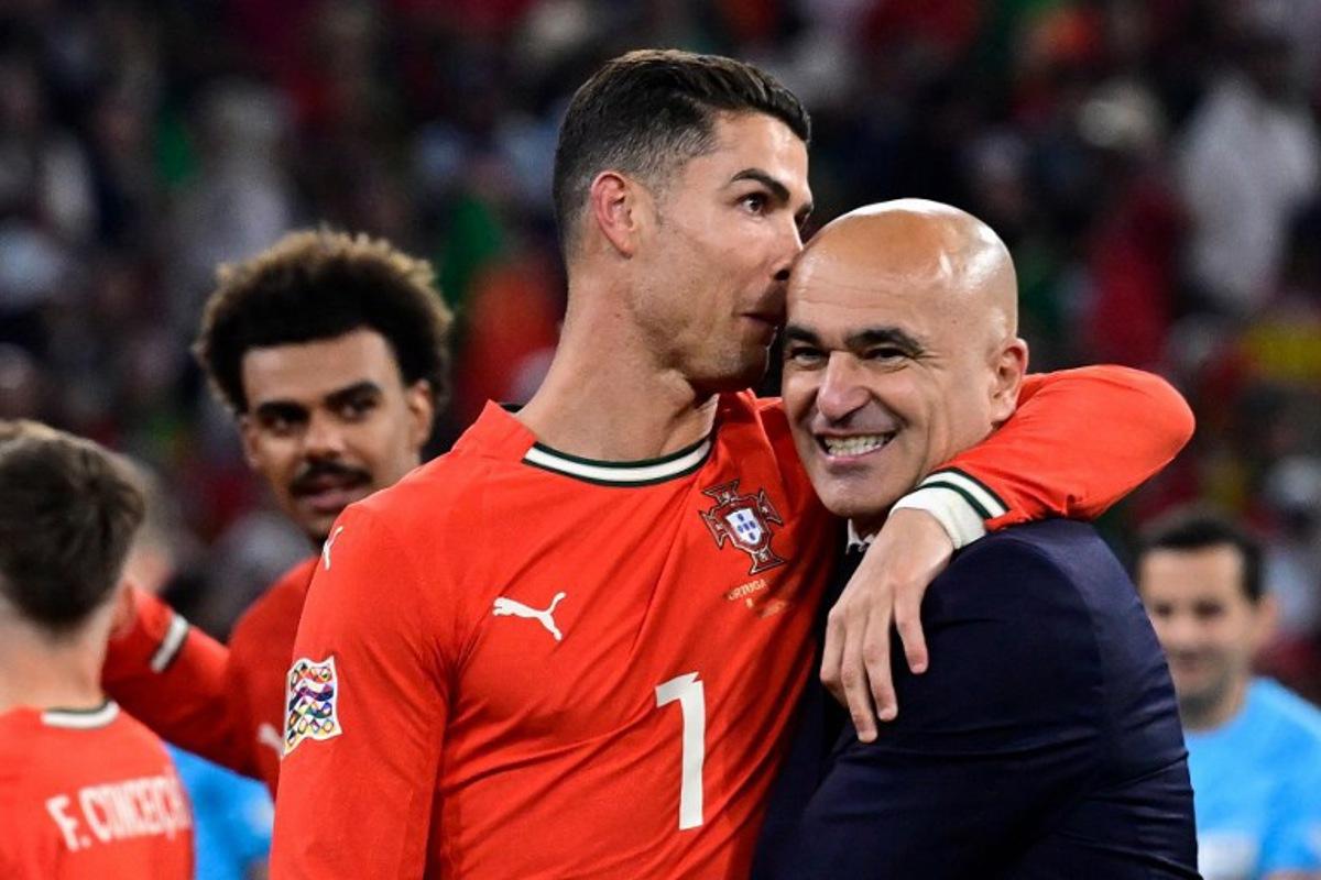 Portugal's forward #07 Cristiano Ronaldo and Portugal's Spanish head coach Roberto Martinez celebrate winning the UEFA Nations League final football match between Portugal and Spain in Munich, southern Germany on June 8, 2025.  John MACDOUGALL / AFP