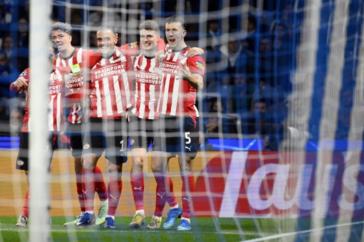 PSV Eindhoven's Dutch midfielder #20 Guus Til (2R) celebrates with teammates after scoring the opening goal during the UEFA Champions League first round day 3 football match between FC Porto and PSV Eindhoven at Dragao stadium in Porto, on October 20, 2026  Miguel RIOPA / AFP