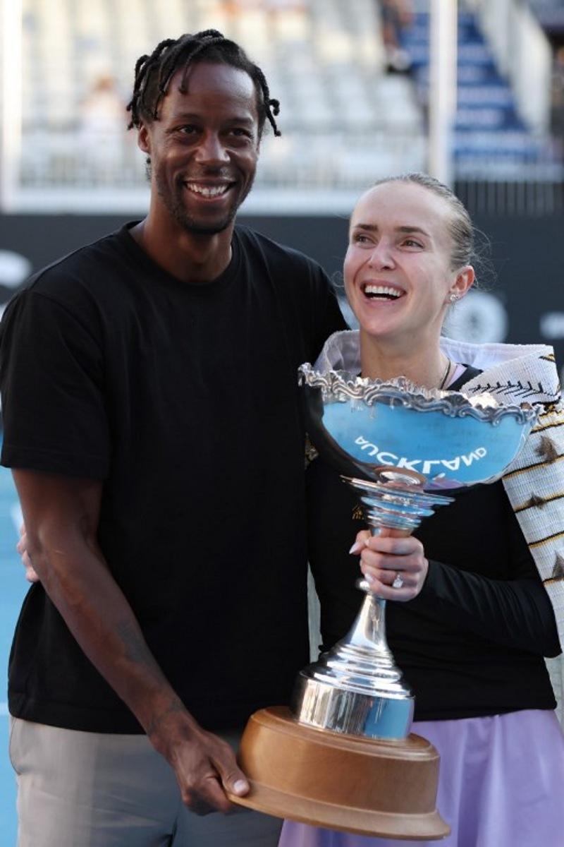 Ukraine's Elina Svitolina celebrates with the trophy and husband Gael Monfils after her win against China's Wang Xinyu during the women's singles final at the WTA Auckland Classic tennis tournament in Auckland on January 11, 2026.  Michael Bradley / AFP
