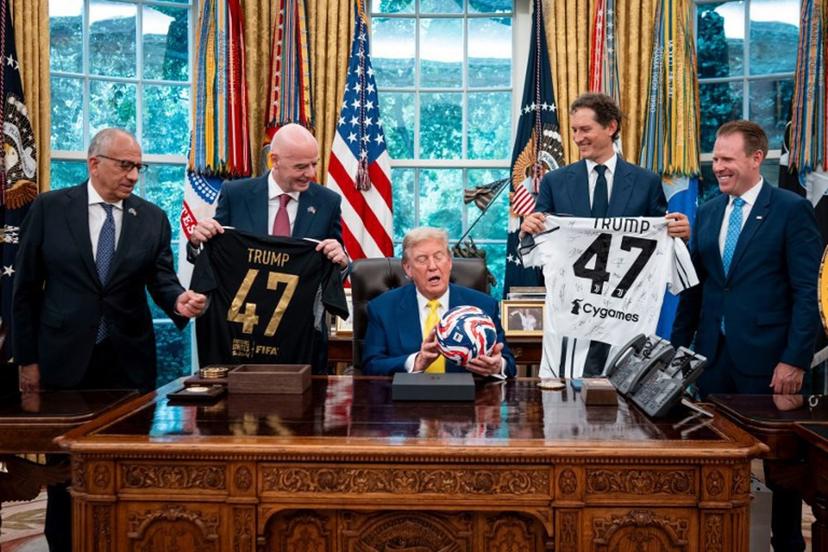 US President Donald Trump (C) flanked by (L/R) Carlos Cordeiro, former president of the United States Soccer Federation, FIFA President Gianni Infantino, Chairperson of Ferrari John Elkann and Executive Director of the presidential task force for the 2026 FIFA World Cup Andrew Giuliani, holds a ball as he makes remarks in the Oval Office of the White House during a visit by members of Italian soccer club Juventus in Washington, DC, on June 18, 2025. Juventus will play Emirati club Al-Ain in the 2025 FIFA Club World Cup at Washington's Audi Field later in the day. Doug Mills / POOL / AFP
