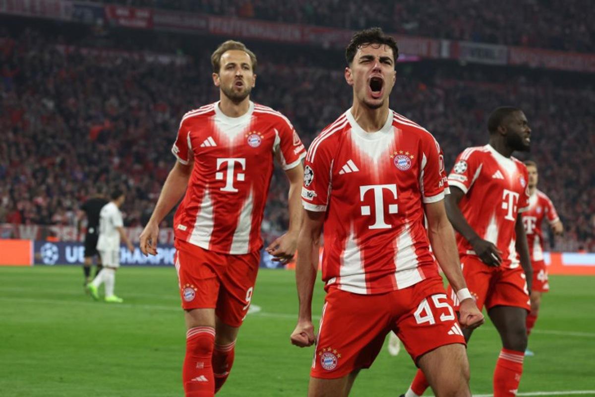 Bayern Munich's German midfielder #45 Aleksandar Pavlovic (C) celebrates followed by Bayern Munich's English forward #09 Harry Kane (L) after scoring the 1-1 equalizing goal during the UEFA Champions League quarter-final second leg football match between FC Bayern Munich and Real Madrid in Munich, southern Germany, on April 15, 2026.  Karl-Josef HILDENBRAND / AFP