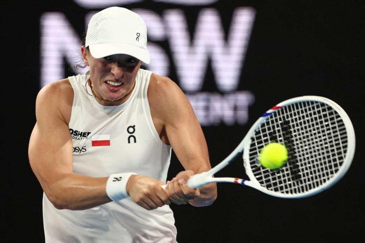 Poland's Iga Swiatek hits a return to Germany's Eva Lys during their women's singles match at the United Cup tennis tournament in Ken Rosewall Arena, Sydney on January 5, 2026. Izhar KHAN / AFP