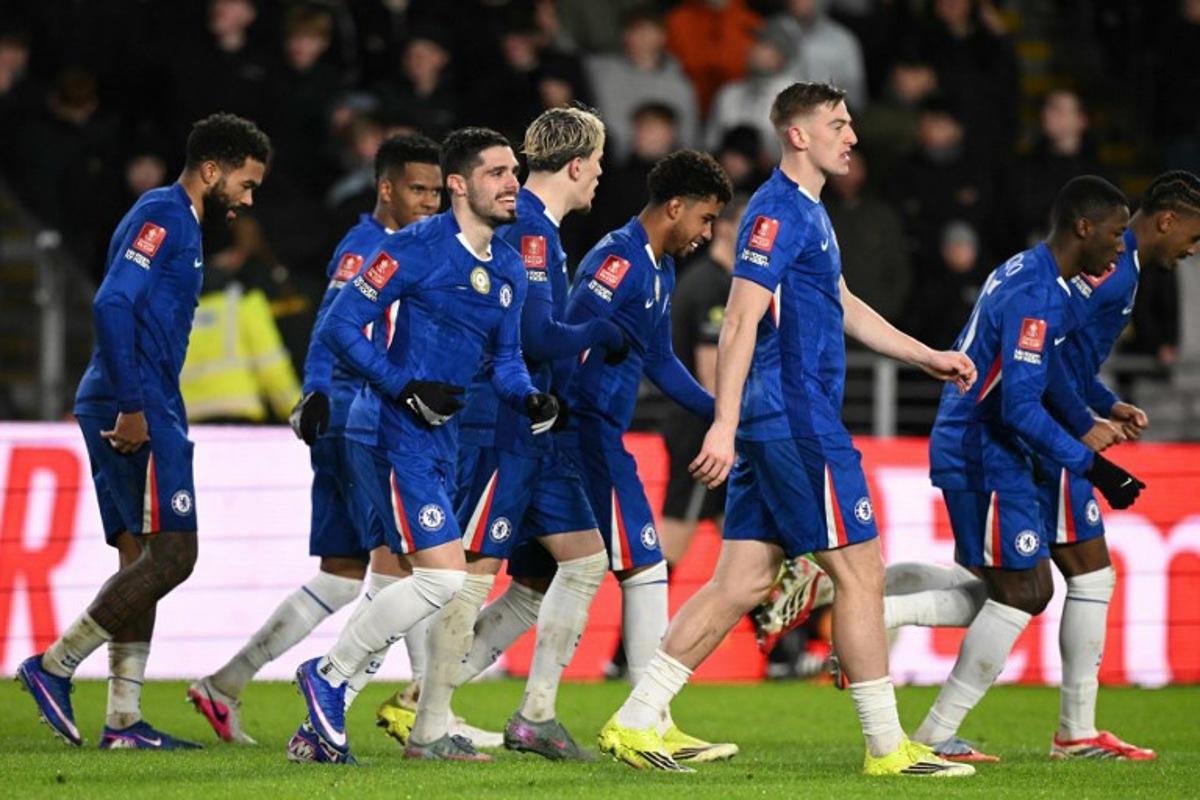 Chelsea's Portuguese midfielder #07 Pedro Neto (3L) smiles as Chelsea players celebrate their second goal scored direct from the corner take by Neto during the English FA Cup fourth round football match between Hull City and Chelsea at the MKM Stadium in Kingston upon Hull, north east England on February 13, 2026. Oli SCARFF / AFP