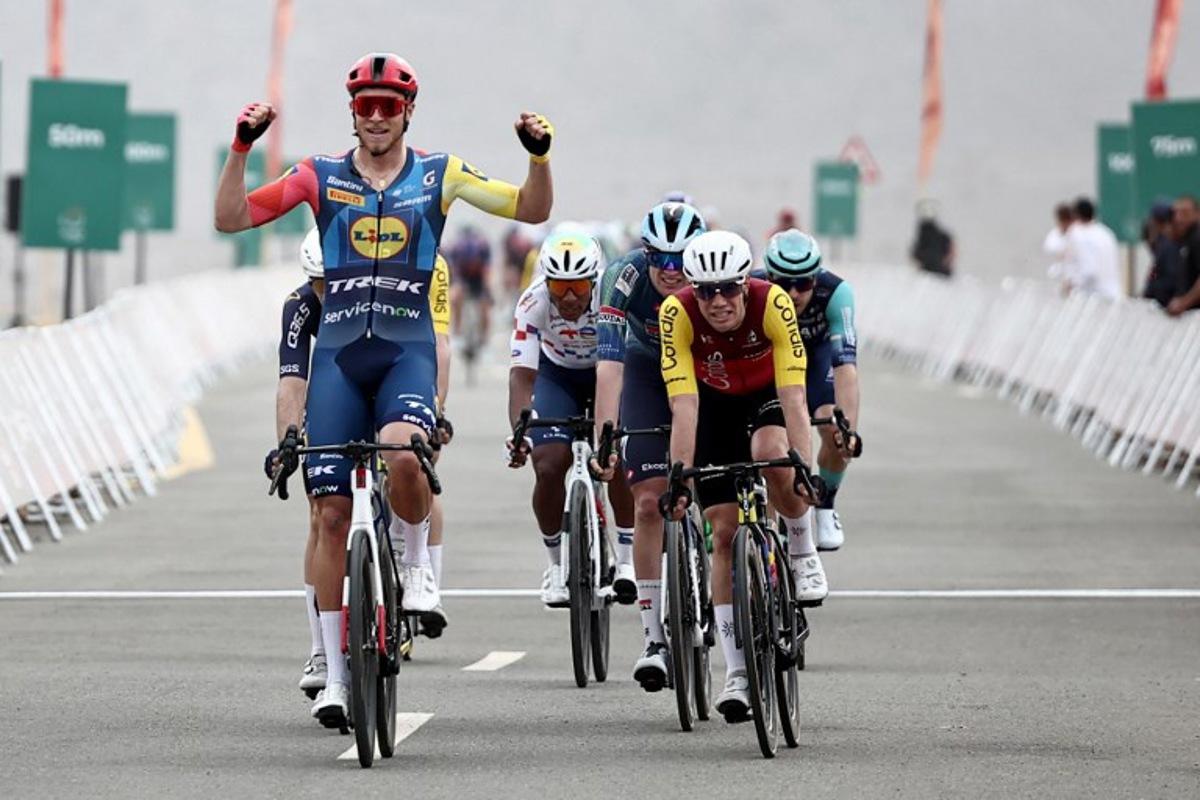 Lidl-Trek cycling team's Italian rider Jonathan Milan celebrates as he crosses the finish line to win the first stage of the AlUla Tour cycling race, a 158 km race started and finished in the Saudi desert city of AlUla, on January 27, 2026. Anne-Christine POUJOULAT / AFP