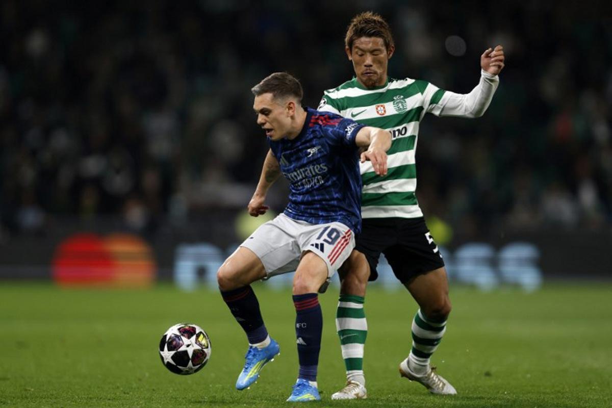 Arsenal's Belgian midfielder #19 Leandro Trossard and Sporting Lisbon's Japanese midfielder #05 Hidemasa Morita fight for the ball during the UEFA Champions League quarter final first leg football match between Sporting CP and Arsenal at Jose Alvalade stadium in Lisbon on April 7, 2026. FILIPE AMORIM / AFP