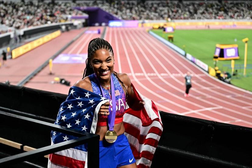 US' athlete Tara Davis-Woodhall celebrates with her country's flag after winning the women's long jump final during the World Athletics Championships in Tokyo on September 14, 2025. Yuichi YAMAZAKI / AFP