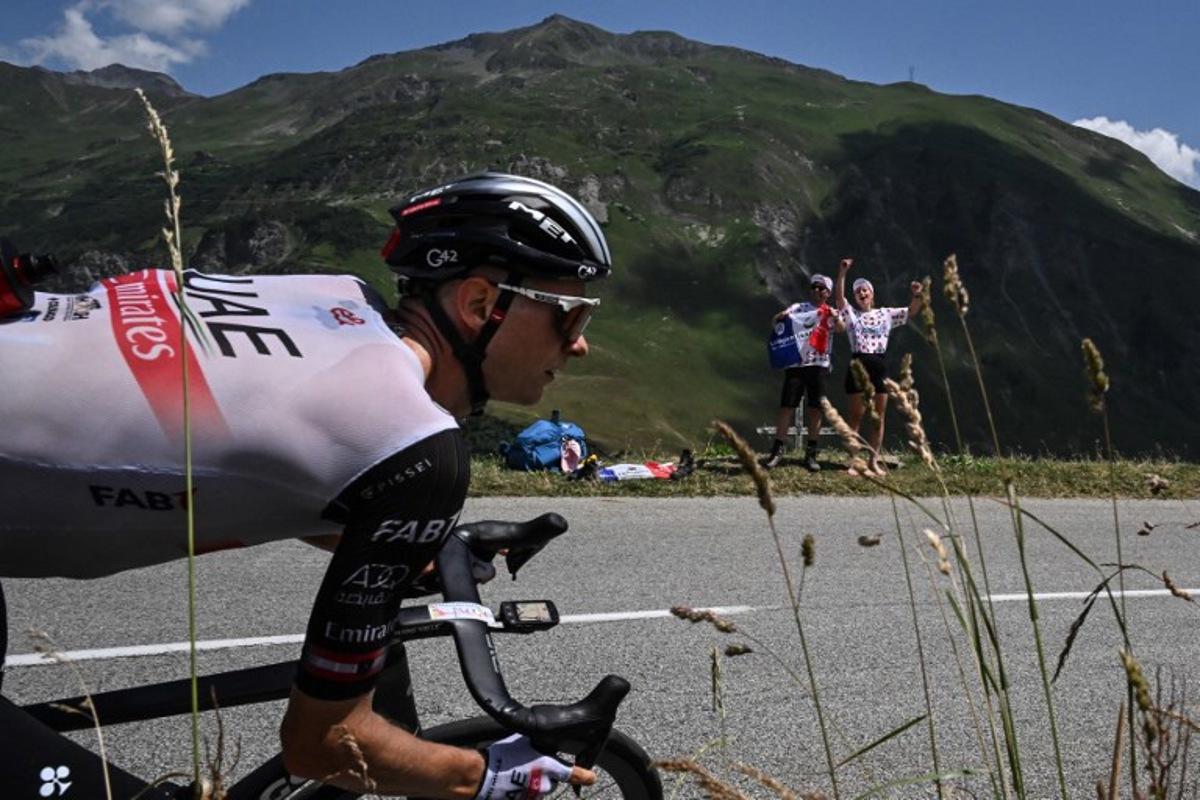 Spectators cheer along the roadside as UAE Team Emirates' Austrian rider Felix Grossschartner cycles past during the 17th stage of the 110th edition of the Tour de France cycling race, 166 km between Saint-Gervais Mont-Blanc and Courchevel, in the French Alps, on July 19, 2023. Marco BERTORELLO / AFP
