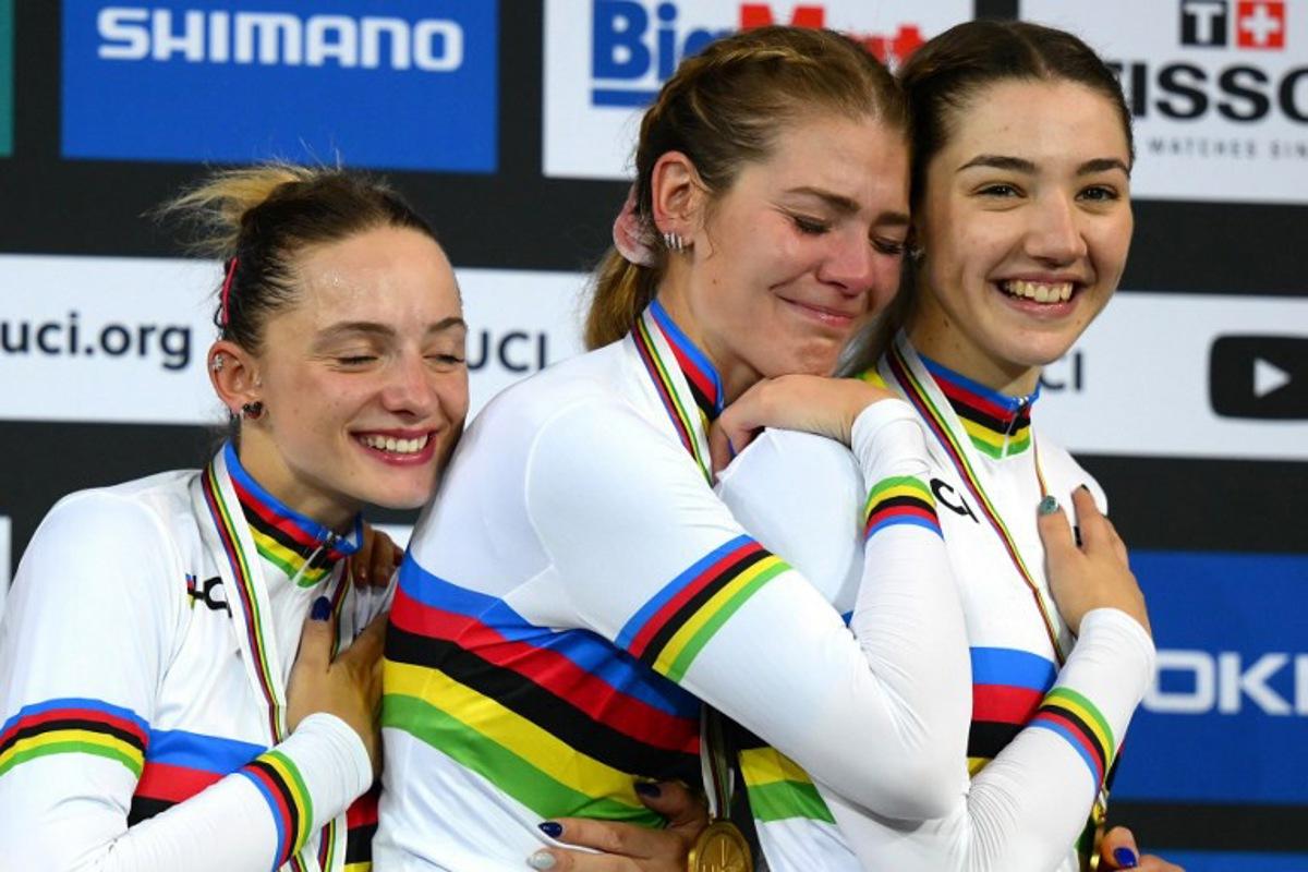 (From L)Italy's Chiara Consonni, Italy's Martina Alzini and Italy's Martina Fidanza celebrate with their gold medals on the podium after winning the Women's Team Pursuit finals during the UCI Track Cycling World Championships at the Velodrome of Saint-Quentin-en-Yvelines, southwest of Paris, on October 13, 2022. Anne-Christine POUJOULAT / AFP