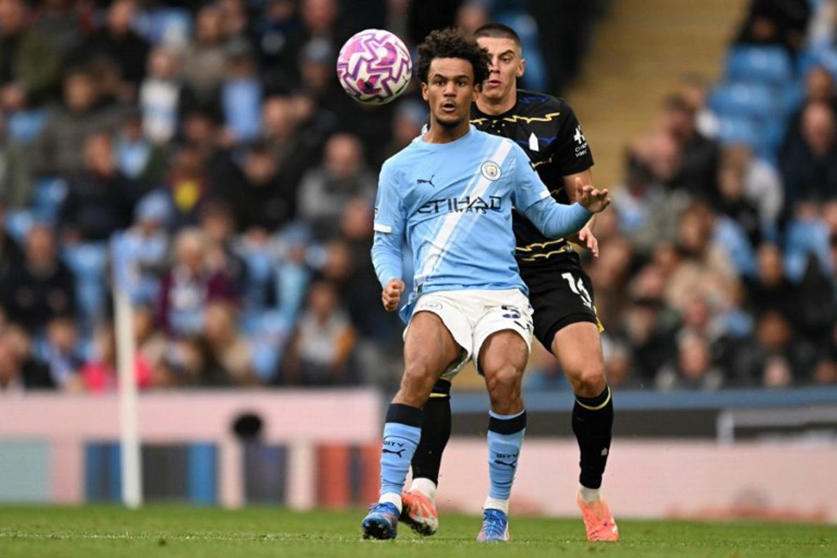 Manchester City's Norwegian midfielder #52 Oscar Bobb battles for the ball with Everton's Ukrainian defender #16 Vitaliy Mykolenko during the English Premier League football match between Manchester City and Everton at the Etihad Stadium in Manchester, north west England, on October 18, 2025. Oli SCARFF / AFP