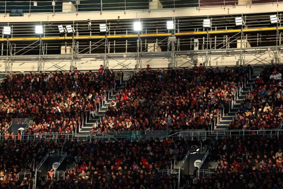 Fans watch the game from the stands during the Spanish league football match between FC Barcelona and Athletic Club Bilbao at Camp Nou Stadium in Barcelona on November 22, 2025. Josep LAGO / AFP