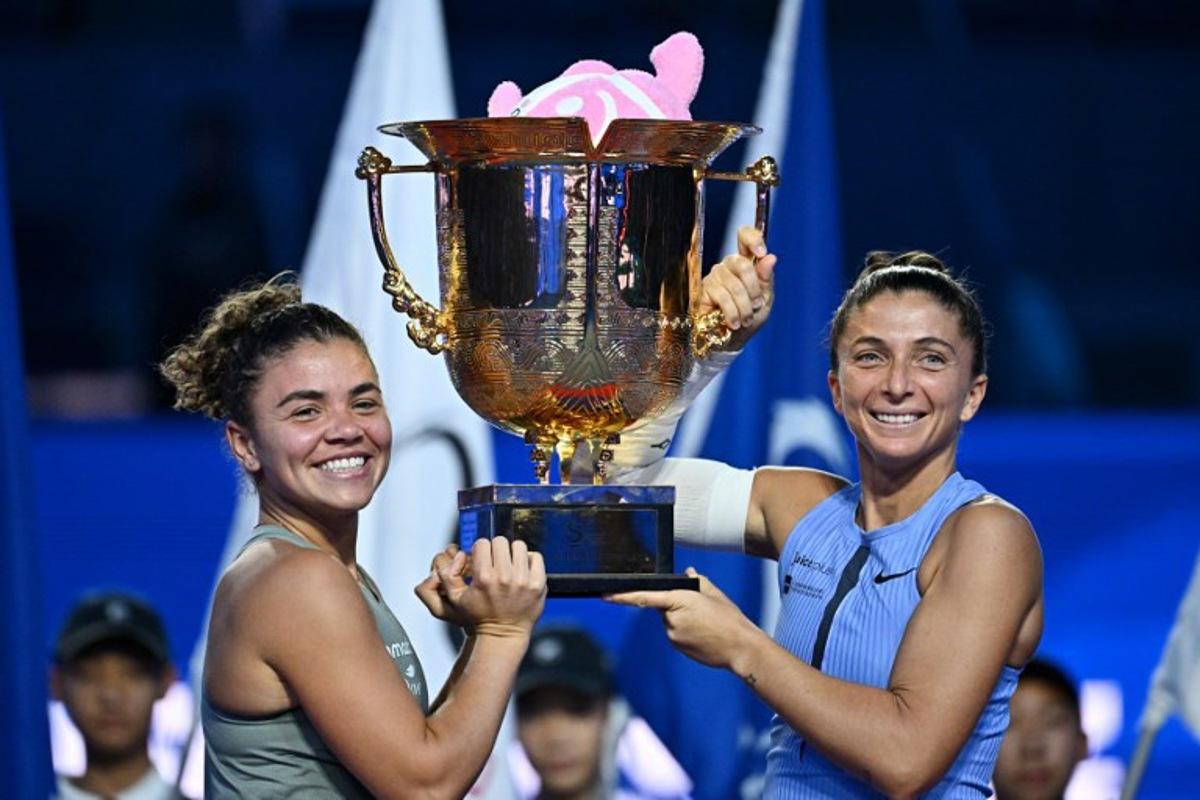 Italy's Sara Errani (R) and Jasmine Paolini celebrate with their trophy after winning their women's doubles final against Japan's Miyu Kato and Hungary's Fanny Stollar at the China Open tennis tournament in Beijing on October 5, 2025. Pedro Pardo / AFP