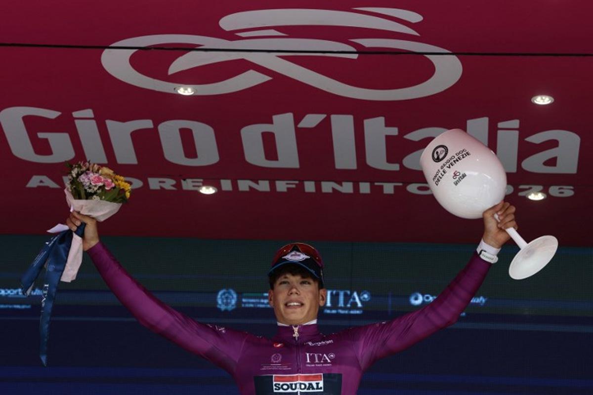 Soudal Quick-Step French rider Paul Magnier celebrates his mauve jersey (Maglia Ciclamino) of best sprinter on the podium after the 10th stage of the Giro d'Italia 2026 - Tour of Italy cycling race, 42km individual time trial between Viareggio and Massa on May 19, 2026. , Luca Bettini / AFP