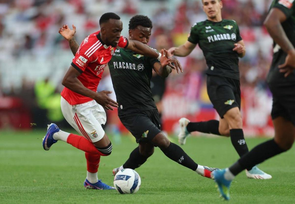 SL Benfica's Belgian forward #11 Dodi Lukebakio fights for the ball with Moreirense's English midfielder #23 Nile John during the Portuguese League football match between SL Benfica and Moreirense FC at Luz Stadium in Lisbon on April 25 , 2026. PATRICIA DE MELO MOREIRA / AFP