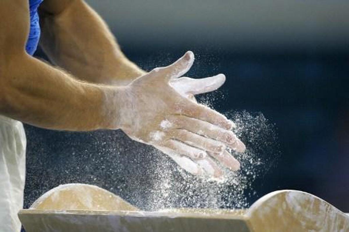An athlete powders his hands prior to an exercice during the gymnastic men's team event of the XV Mediterranean Games, 25 June 2005 in Almeria, southern Spain. AFP PHOTO PHILIPPE DESMAZES DV