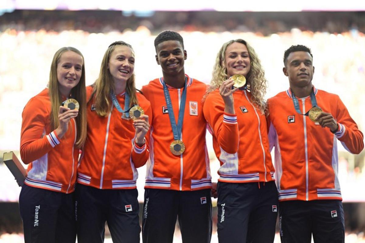 Gold medallists Netherlands' Isaya Klein Ikkink, Eugene Omalla, Lieke Klaver, Femke Bol and Cathelijn Peeters celebrate on the podium after competing in the mixed's 4x400m relay of the athletics event during the Paris 2024 Olympic Games at Stade de France in Saint-Denis, north of Paris, on August 5, 2024. Martin BERNETTI / AFP